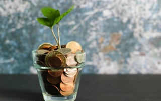 Small plant growing from coins in glass