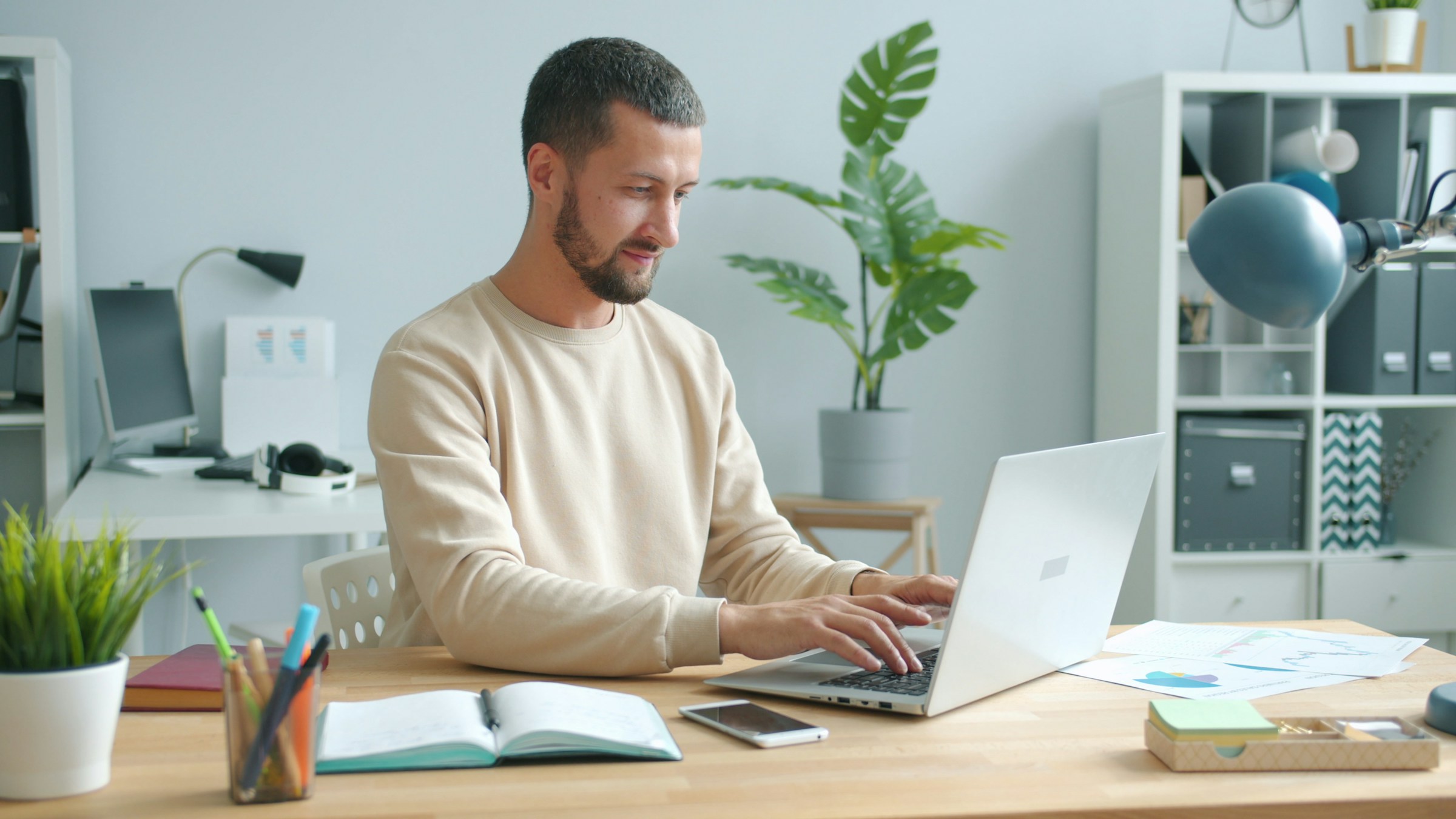 Man working on laptop at home office desk